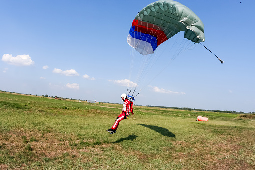 Parachutist lands on the ground.