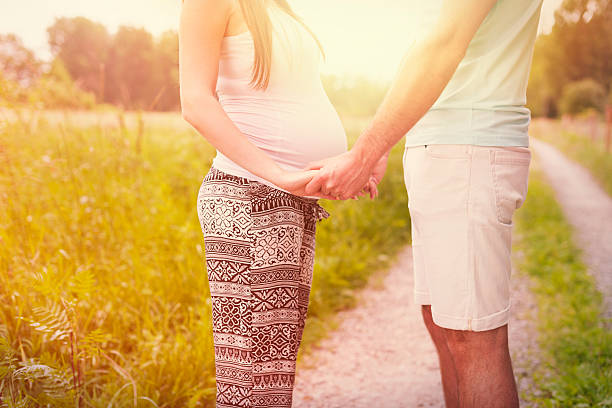 parte inferior de grávida casal apaixonado - couple human pregnancy sunset walking imagens e fotografias de stock