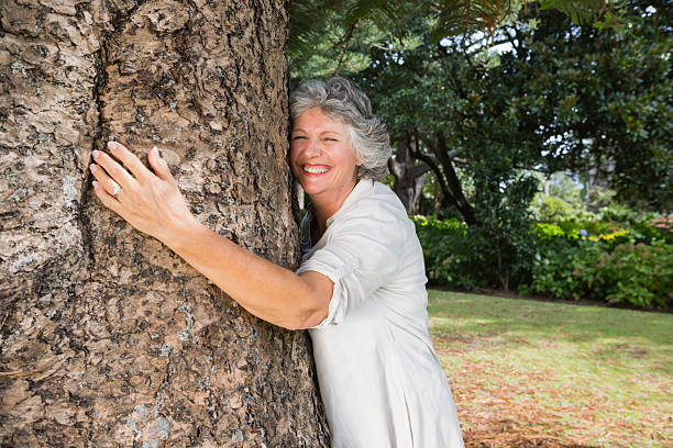 istock Smiling older woman hugging a tree 499621459