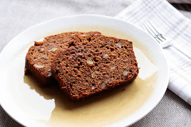 Carrot Walnut Bread Two slices of freshly baked carrot walnut bread on a light yellow plate. carrot cake day stock pictures, royalty-free photos & images