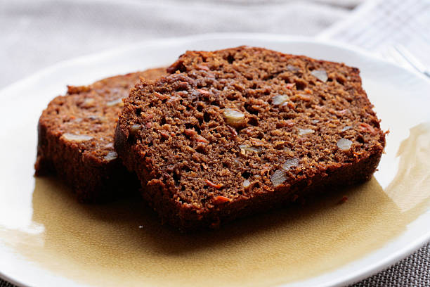 Carrot Walnut Bread Two slices of freshly baked carrot walnut bread on a light yellow plate. carrot cake day stock pictures, royalty-free photos & images