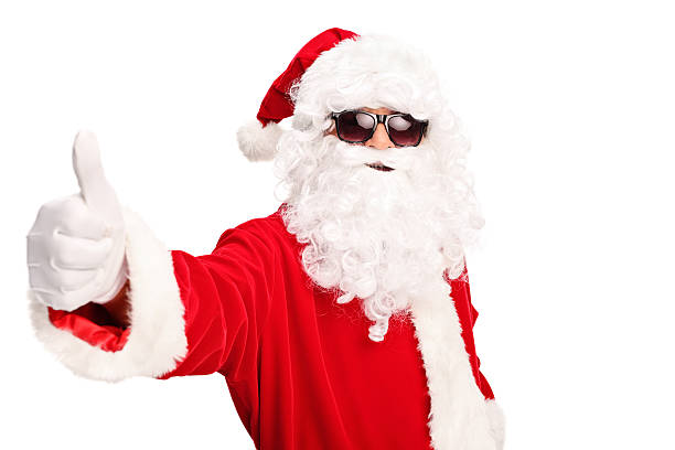 Cool Santa with black sunglasses giving a thumb up and looking at the camera isolated on white background
