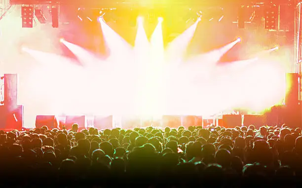 Photo of people music festival concert white orange yellow light ray