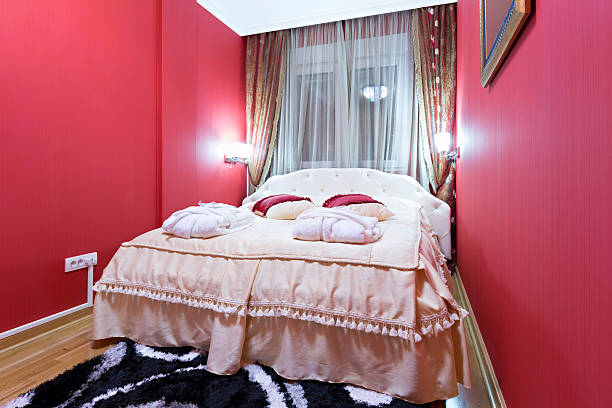 Brown wooden double bed with lamps on nightstands in the bedroom. High quality photo