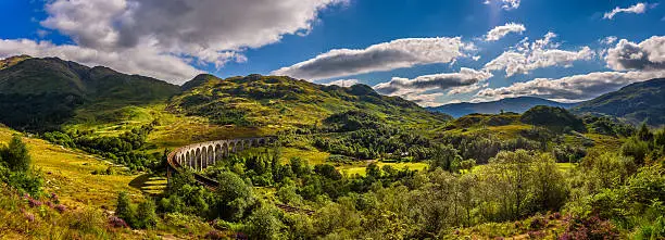 Summer panorama of Glenfinnan Railway Viaduct in Scotland and surrounding mountains