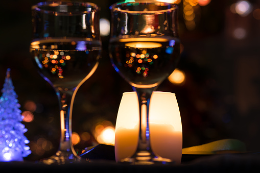 Indistinct festive background with two glasses of wine and color bokeh.