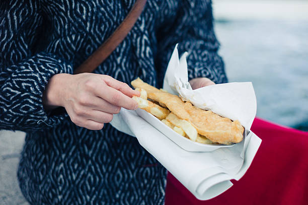 istock Woman eating fish and chips 499632706
