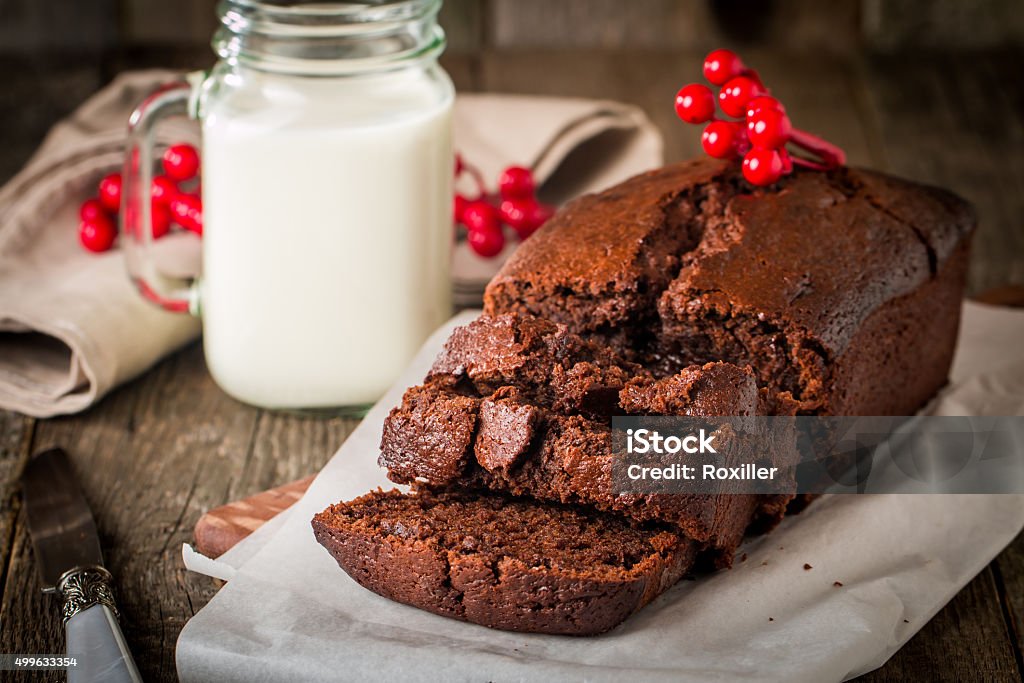 Chocolate-banana Loaf cake on paper Chocolate-banana Loaf cake on paper  on wooden background Baked Stock Photo