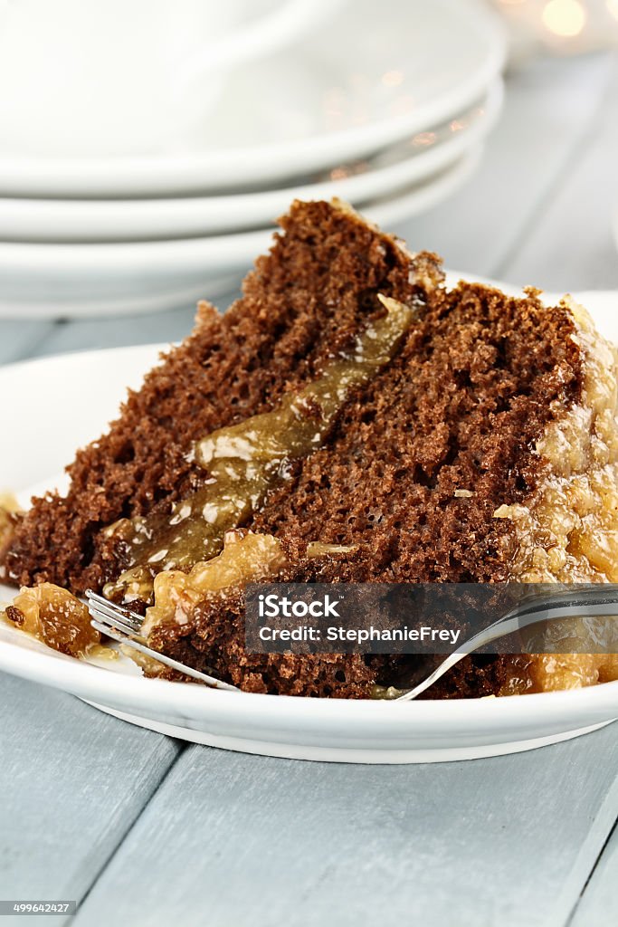 Slice of German Chocolate Cake A slice of German chocolate cake on a plate. Shallow depth of field with selective focus on bite on the fork. Chocolate Cake Stock Photo