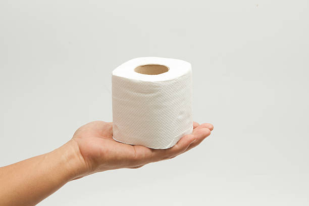 istock hand holding  roll of white toilet paper 499642477