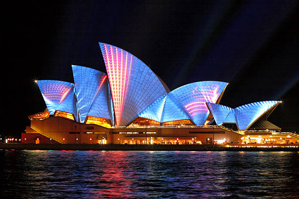 sydney opera hosue iluminado em azul e vermelho movimento fitas contentoras - sydney opera house imagens e fotografias de stock
