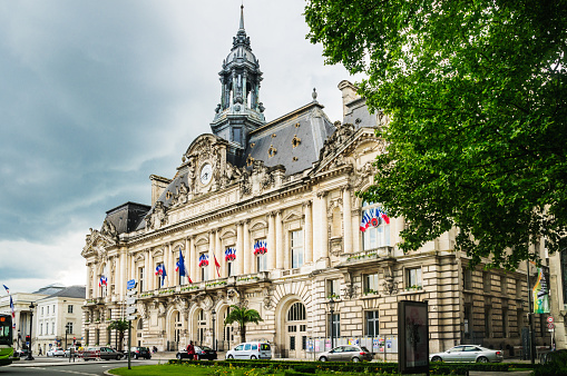 Tours, France - May 27, 2014: The red,white and blue  flag of France is flown in profusion outside the  stately facade of the City Hall (Hotel De Ville) of Tours France.