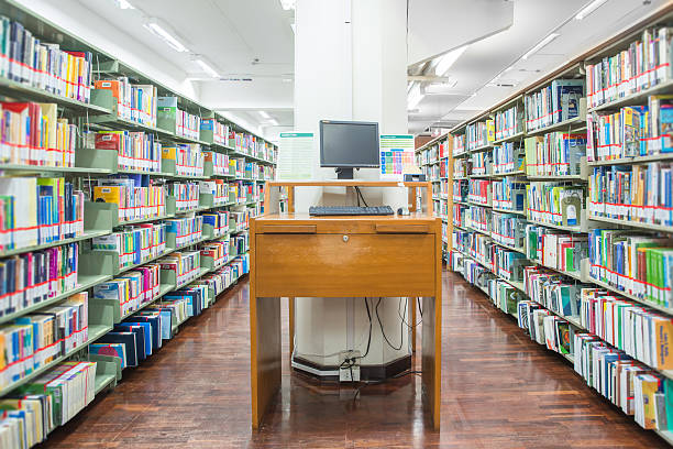 istock computer in a library with many books and shelves 499644675