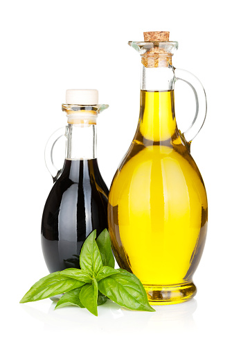 Olive oil and vinegar bottles with basil. Isolated on white background