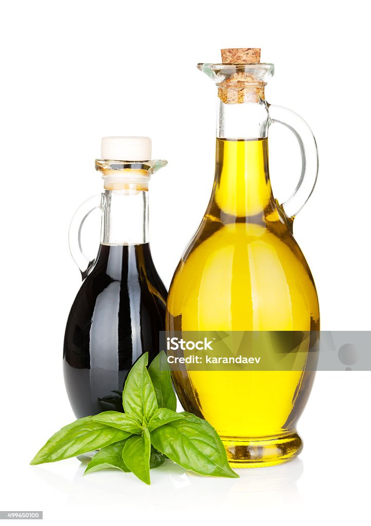 Olive oil and vinegar bottles with basil Olive oil and vinegar bottles with basil. Isolated on white background Vinegar Stock Photo