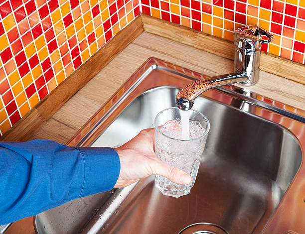 istock Filling up a glass with water from kitchen tap POV 499653072
