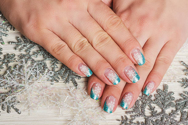Winter nail art with snowflakes and light blue french Winter nail art with snowflakes and light blue french on wooden background christmas nails stock pictures, royalty-free photos & images