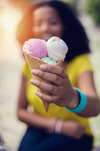 Mixed race woman with ice-cream outside