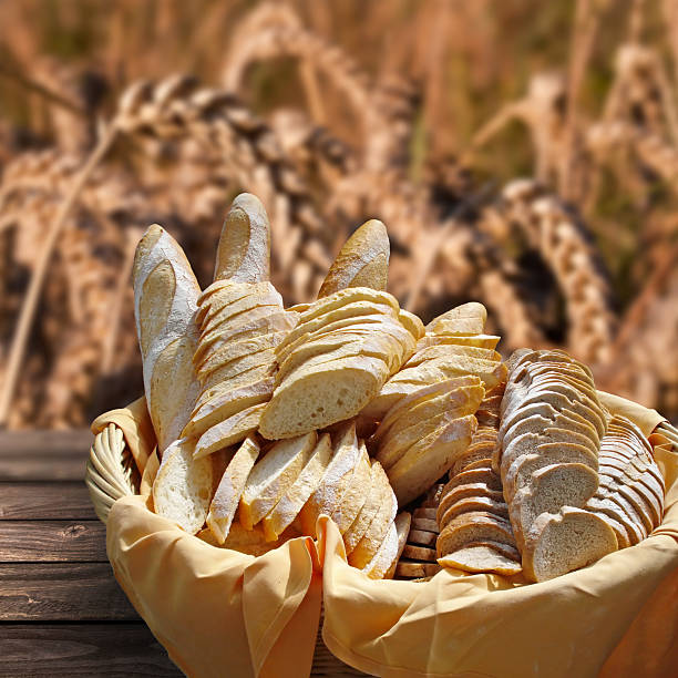 istock Basket of fresh bread, wheat field background 499658771
