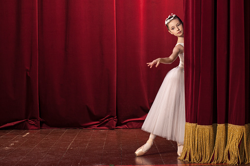 allet dancer on stage, holding a flower, curtain, stage