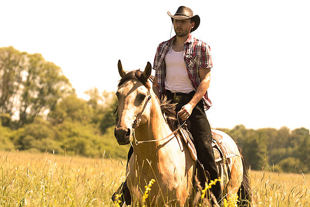 istock young cowboy man ridig with horse 499660699