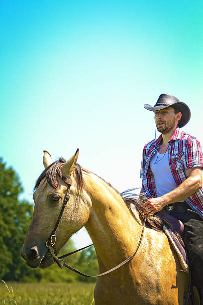 istock young cowboy man ridig with horse 499661915