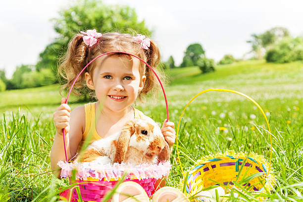 istock Smiling girl with cute rabbit and baskets in park 499662263