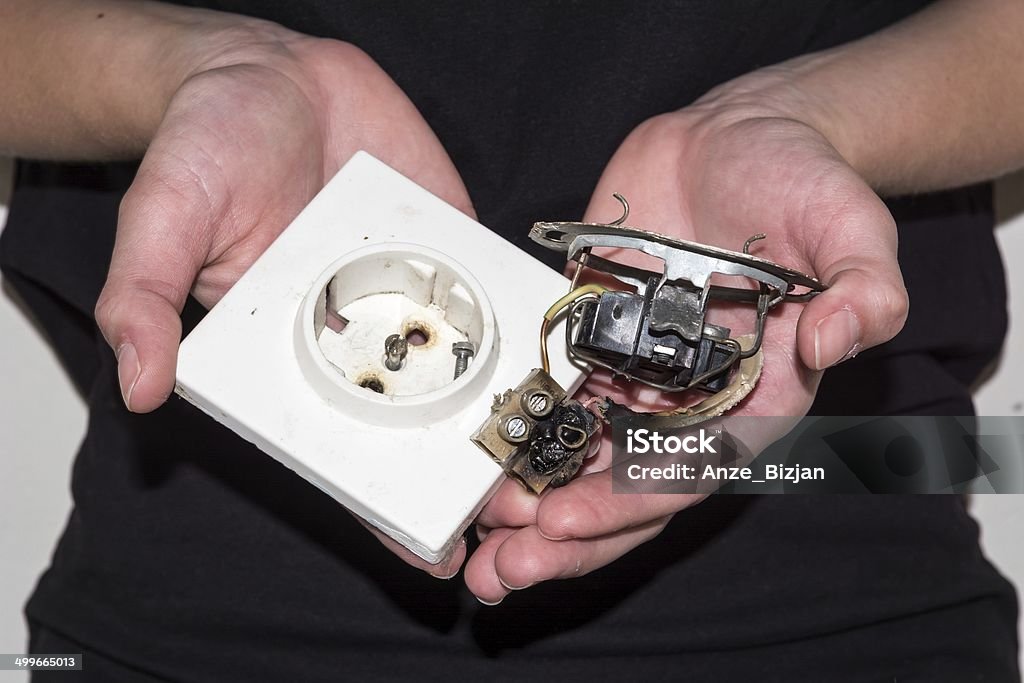 Person hält eine beschädigte elektrische Steckdose - Lizenzfrei Abgerissen Stock-Foto