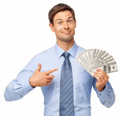 Portrait of confident young businessman pointing at fanned dollar bills over white background. Horizontal shot.