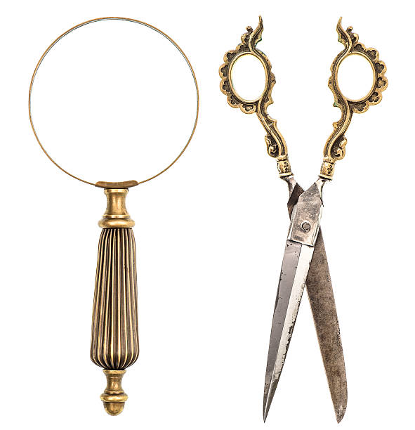 istock Antique magnifying glass and scissors isolated on white 499673781