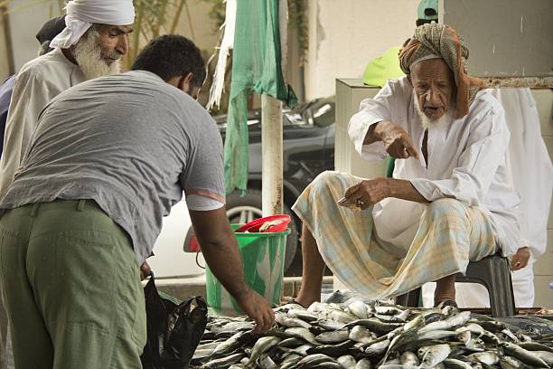 Muttrah, Oman - December 15, 2012: selling the fish at the Muttrah fish market, early in the morning. A client is making his choice.