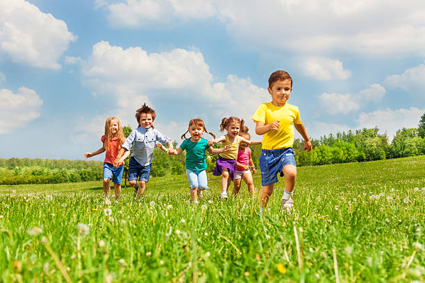 istock Running kids in green field during summer 499674693