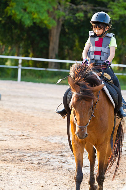 istock child trains horse riding , 499675791