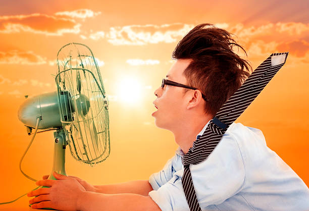 熱波の中、ビジネスの男性手、電動ファン - summer cool electric fan heat ストックフォトと画像