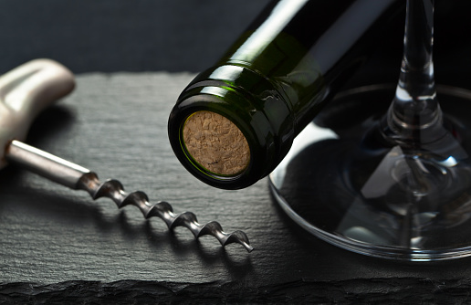 red wine bottle and corkscrew , focus on a center