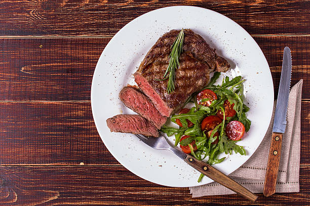 costilla al con roqueta y tomates. - steak grilled beef plate fotografías e imágenes de stock