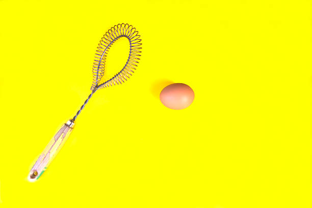 istock Brown Egg, Old Wire Whisk, Vibrant Yellow Background 499687128