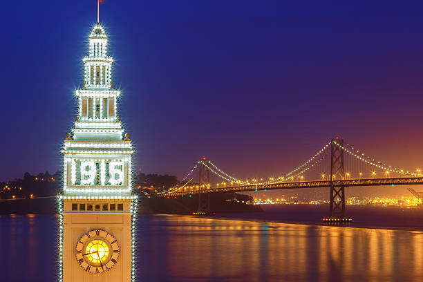 Ferry Building and Bay Bridge illuminated at night in San Francisco, California, USA