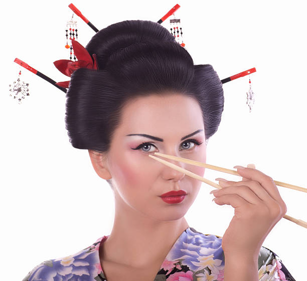 Young woman in Japanese kimono with chopsticks stock photo