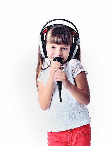 istock little girl singing into a microphone, karaoke 499692986