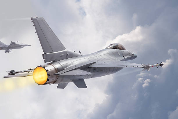 F-16 Fighting Falcon jets fly through clouds stock photo