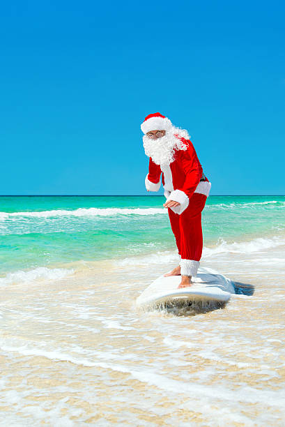 istock Santa Claus windsurfer go surfing with surfboard at ocean waves 499694388