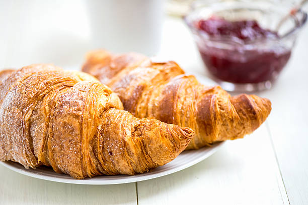 istock Fresh Croissants with Icing, Cup of Tea and Strawberry Jam 499694592