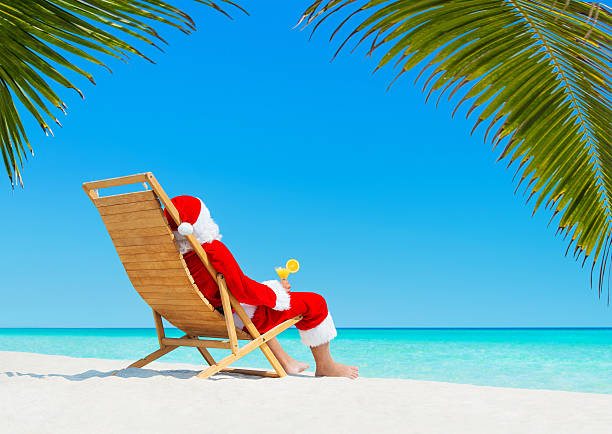 christmas santa claus com cocktail na praia tropical deckchair em - christmas beach sun tropical climate imagens e fotografias de stock