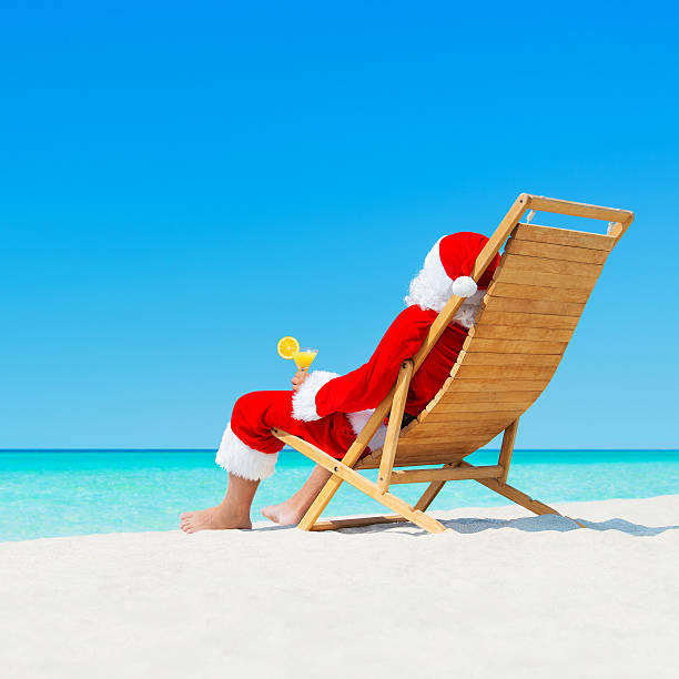 boże narodzenie santa claus z koktajl na tropikalnej plaży sunlounger w - tanning bed brown relaxation resting zdjęcia i obrazy z banku zdjęć