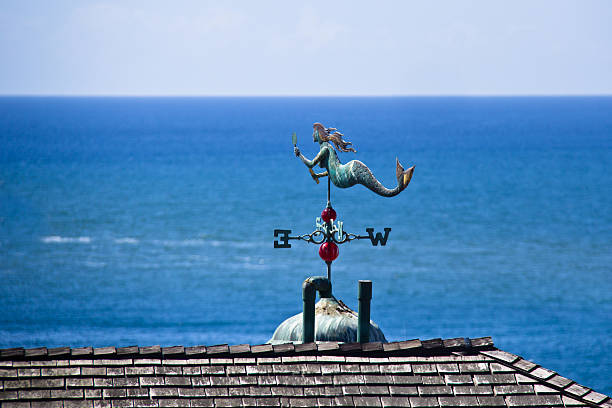 Copper Mermaid wather vane on rooftop overlooking ocean