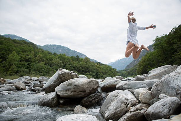 glückliche frau springen mit freude in der natur - arms outstretched teenage girls jumping flying stock-fotos und bilder