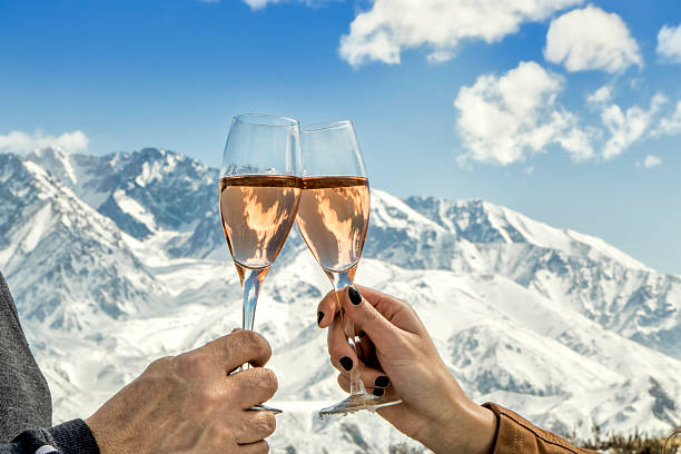 Celebration with rosé champagne Couple in celebration with rosé champagne at foot of the snowy Alps. rose champagne stock pictures, royalty-free photos & images