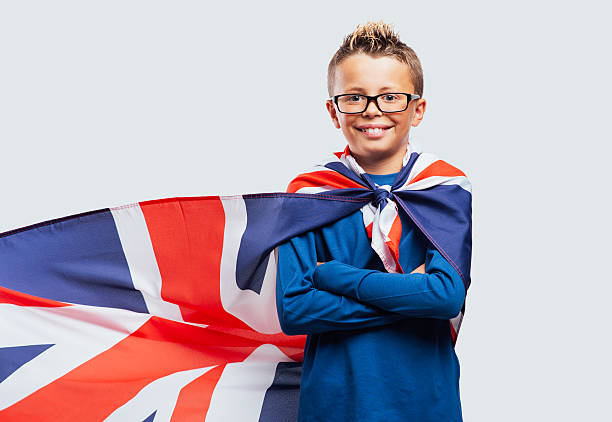 istock Smiling superhero boy with British flag cape 499699332