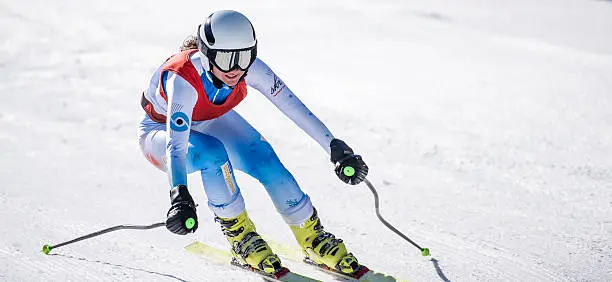 Close up shot of a professional female alpine skier in low pose making a turn.